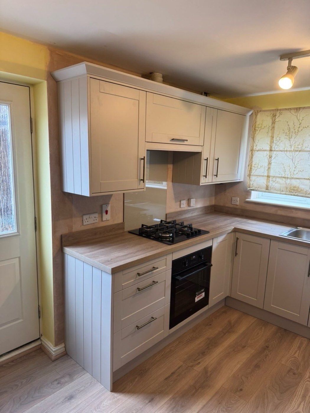 Cream shaker kitchen with oak worktops and black hob
