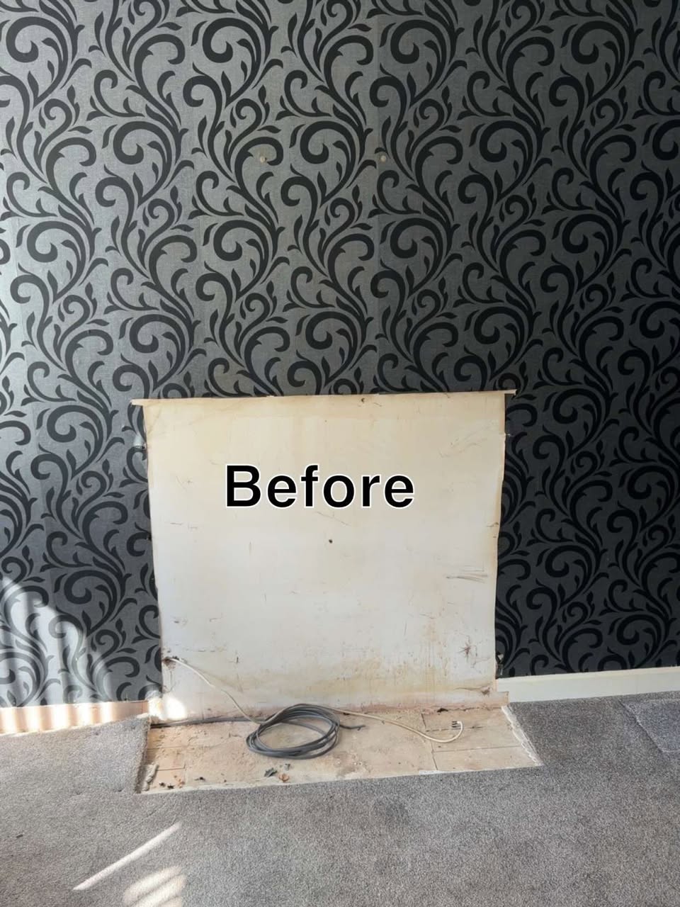 Before: old fireplace opening on a papered chimney breast